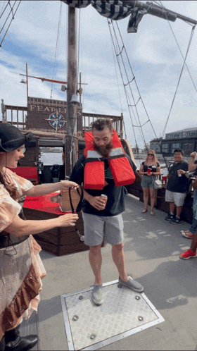 a man wearing a life jacket is standing on a boat