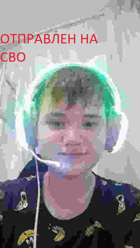 a young boy wearing headphones and a microphone is looking at the camera .