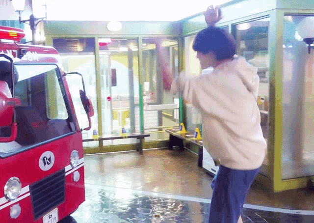 a man is standing in front of a red fire truck with a license plate that says rj