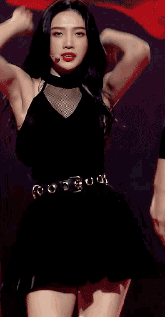 a woman in a black dress with a belt that says ' o ' on it