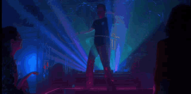 a silhouette of a man standing in front of a crowd in a club