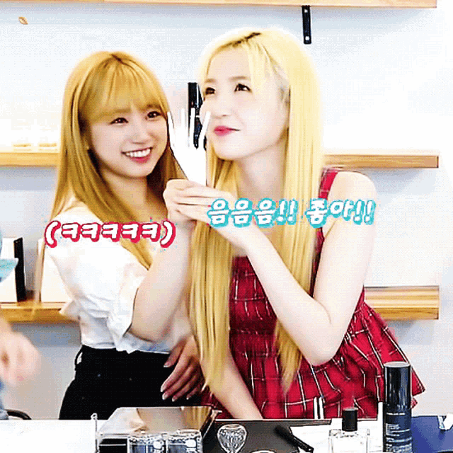 a woman with blonde hair is holding another woman 's hand and says ' eeeee ' in red letters