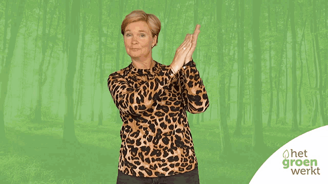 a woman wearing a leopard print shirt stands in front of a green background with het groen werkt written on it