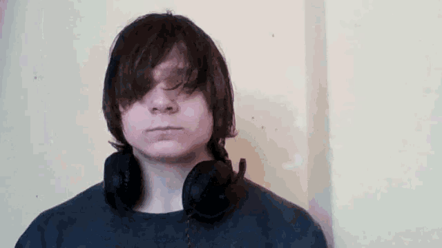 a young man wearing headphones and a blue shirt