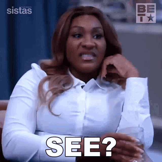 a woman in a white shirt is holding a glass and says see