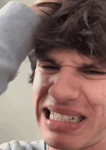 a close up of a man 's face with a tear running down his cheek