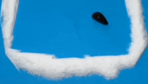 a worm is crawling out of a hole in the snow on a blue background