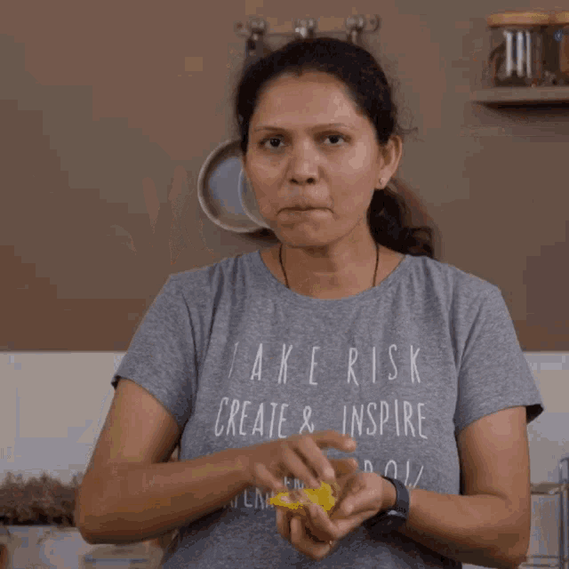 a woman wearing a grey t-shirt that says take risk create and inspire