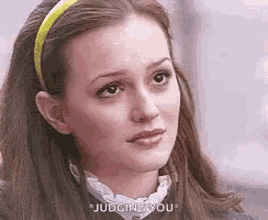 a close up of a woman wearing a yellow headband and a white collar .