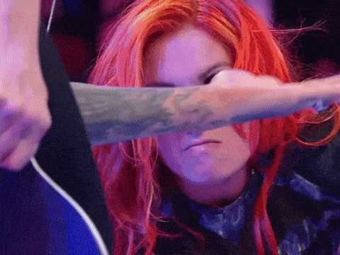 a woman with red hair and a tattoo on her arm