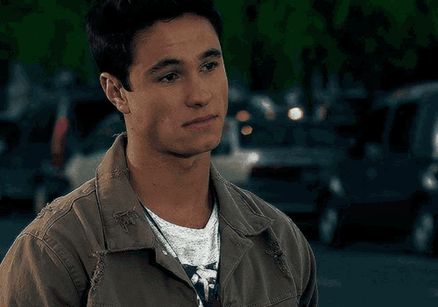 a young man wearing a jacket and a white shirt