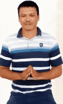 a man wearing a blue and white striped shirt has his eyes closed and his hands folded