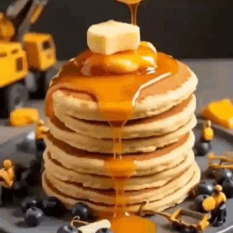 a stack of pancakes with syrup being poured on top .