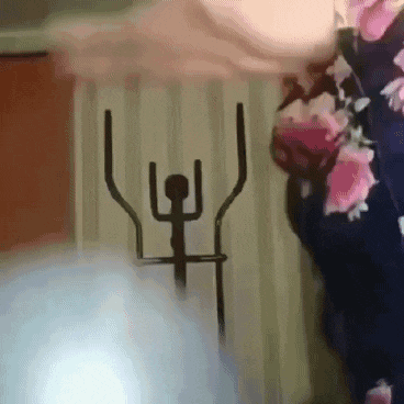 a person is using an exercise bike in front of a wall with flowers on it .