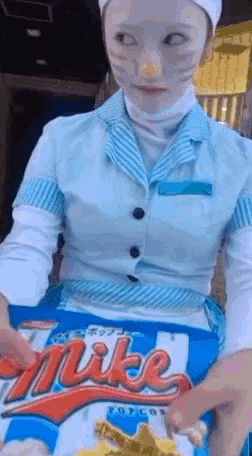 a woman in a blue and white uniform is holding a bag of nike chips