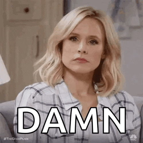 a woman in a plaid shirt is sitting on a couch and making a face .
