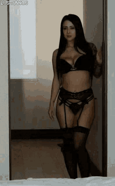 a woman in lingerie is standing in a doorway in a room .