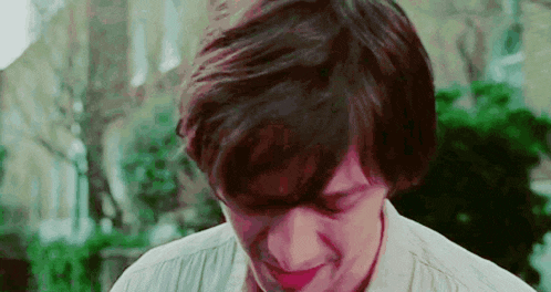 a close up of a young man 's face with his mouth open and his eyes closed .