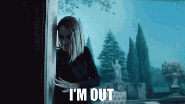a woman standing in front of a window with i 'm out written on the bottom