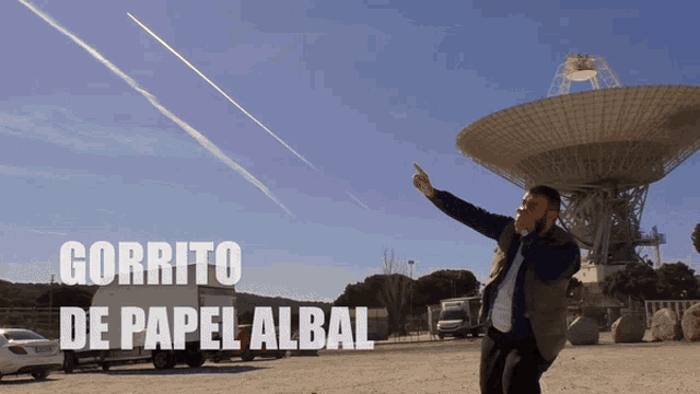 a man standing in front of a satellite dish with the words " gorrito de papel albal " written above him