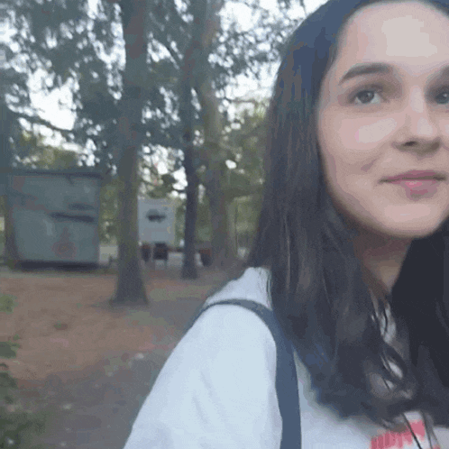 a close up of a girl 's face with trees in the background .