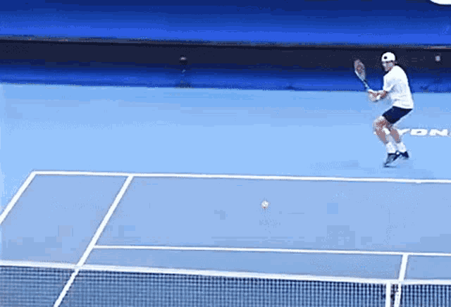 a tennis player is swinging a racket on a court that has yon on it