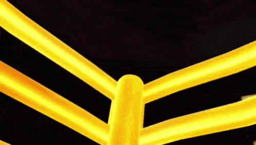 a cartoon character is standing on top of a yellow pole in a boxing ring .