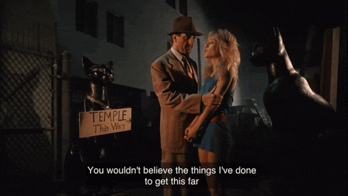 a man and woman are standing in front of a sign that says " temple this way "