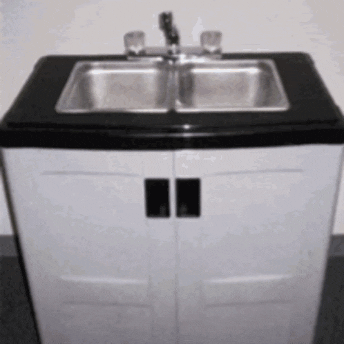 a stainless steel sink sits on a black counter top