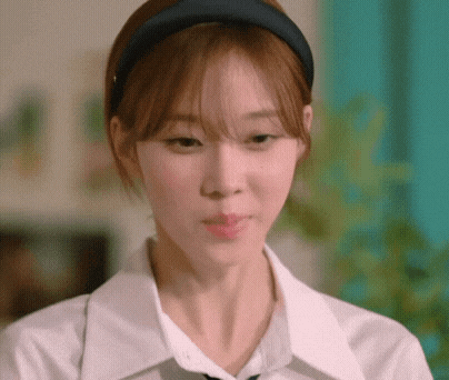 a close up of a woman wearing a headband and a white shirt and tie .