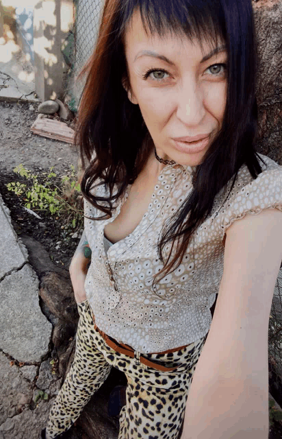 a woman wearing leopard print pants and a white shirt
