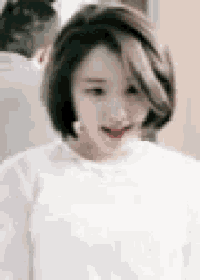 a close up of a woman wearing a white shirt and smiling .