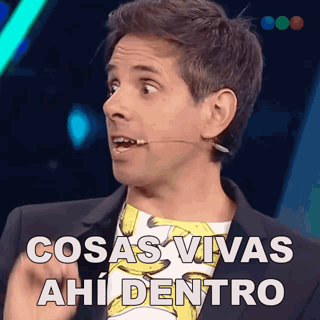 a man with a microphone in his mouth and the words cosas vivas ahi dentro