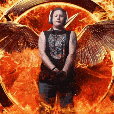 a man wearing headphones stands in front of a circle of flames