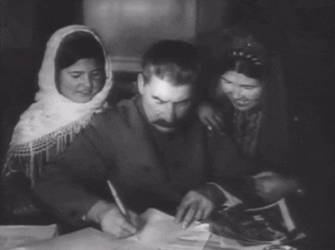 a man with a mustache and a scarf around his head is surrounded by two women