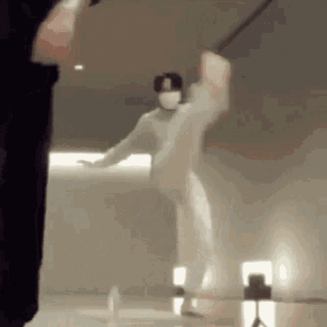 a person wearing a mask is holding a sword in their hand .