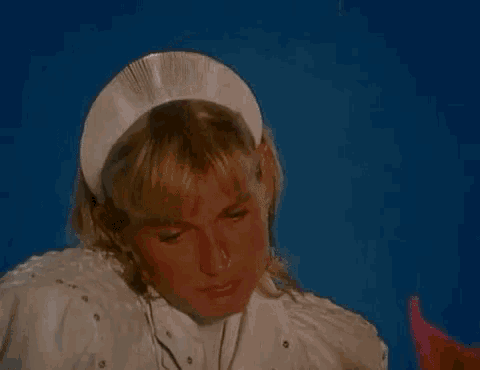a close up of a woman wearing a nurse 's hat and a white shirt .