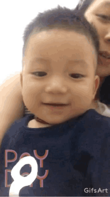 a baby wearing a shirt that says pay day is being held by a woman