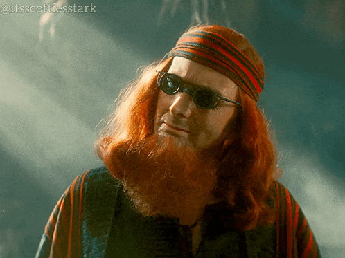 a man with red hair and a beard wearing sunglasses and a headband