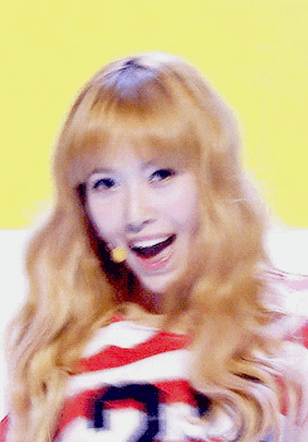 a woman with blonde hair is wearing a red and white striped shirt with the number 22 on the front
