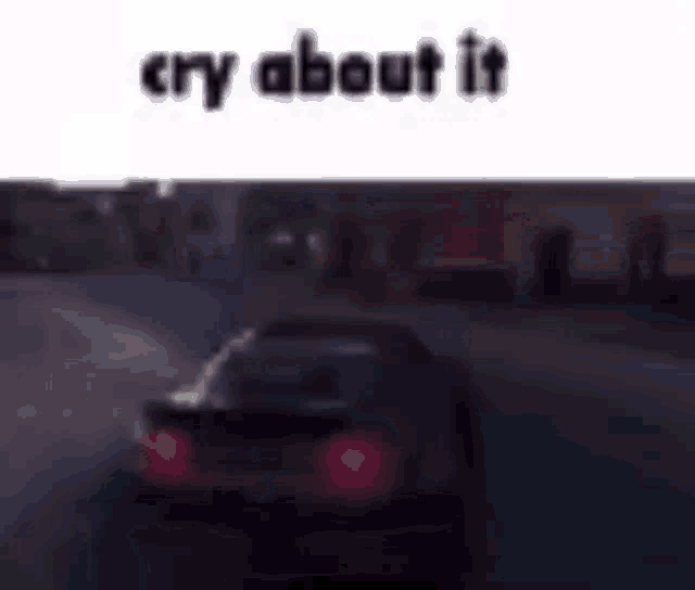 a car is driving down a street at night with the words `` cry about it '' written on the bottom .