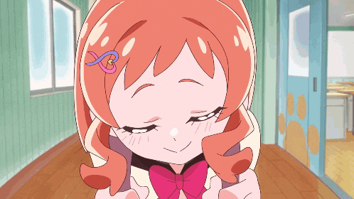 a girl with orange hair and a pink bow is smiling