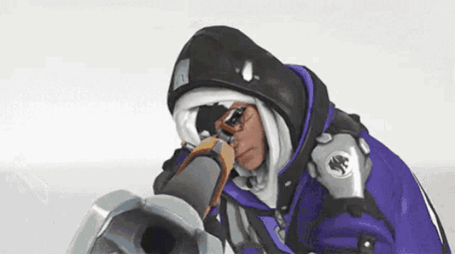 a man in a purple jacket is holding a gun in his hand .