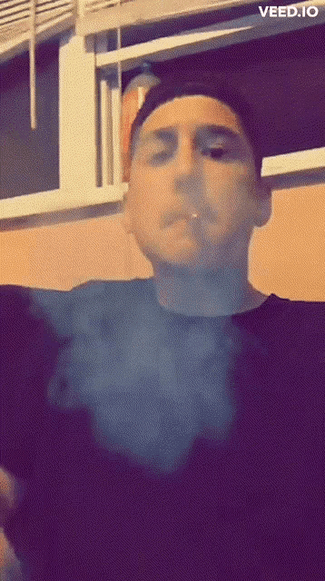 a man smoking a cigarette with the website veed.io visible