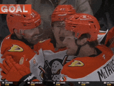 a hockey player wearing a bauer helmet stands next to another player