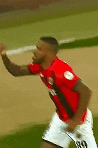 a soccer player wearing a red shirt and white shorts with the number 10 on them