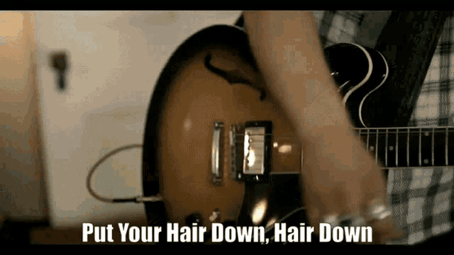 a person playing a guitar with the words put your hair down