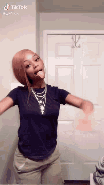 a woman is sticking her tongue out in front of a door ..