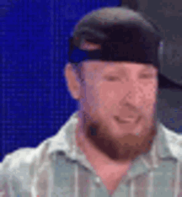 a man with a beard and a hat is smiling .