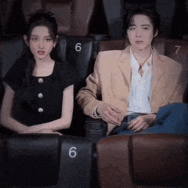 a man and a woman are sitting next to each other in a theater .